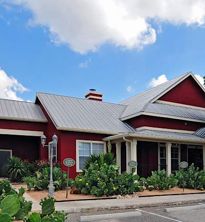 a red house with a metal roof on a street