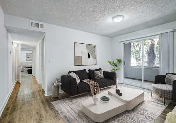 A living room with a black couch and a coffee table.