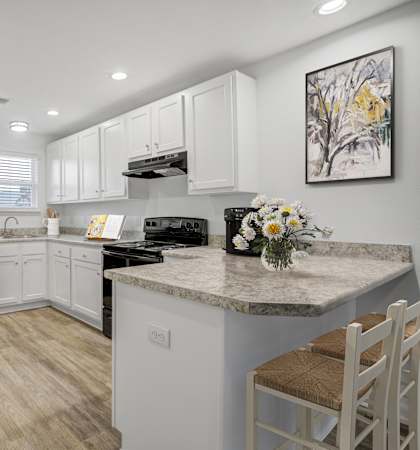 The Marley at Trout River Apartments in Jacksonville, FL 32218 a kitchen with white cabinets and a black refrigerator