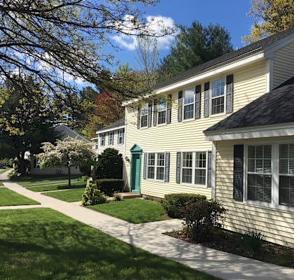 A house with a green door and white siding is shown.