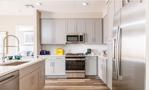 a kitchen with white cabinets and stainless steel appliances