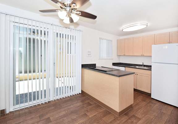 a renovated kitchen with a window and a ceiling fan