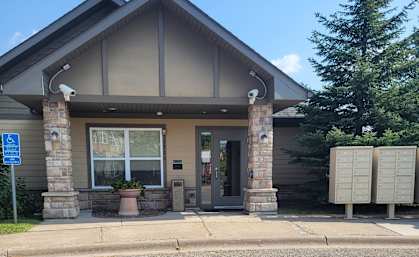 A building with a stone pillar and a grey roof.
