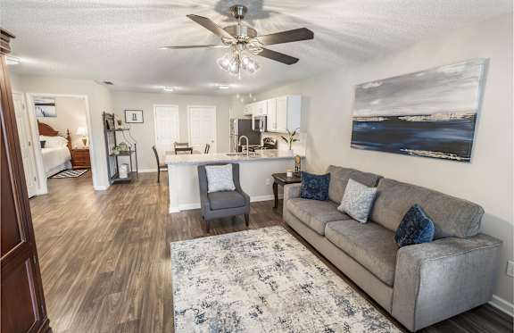 A living room with a couch, coffee table, and a painting on the wall.