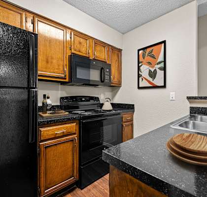 a kitchen with wooden cabinets and black appliances