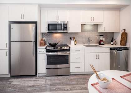 A modern kitchen with a refrigerator, oven, and microwave. at G12 Apartments, Los Angeles, CA, 90015