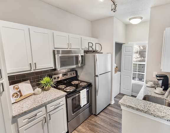 A kitchen with white cabinets and a granite countertop. at The Estates at Brentwood, Brentwood, TN, 37027