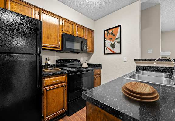 a kitchen with wooden cabinets and black appliances