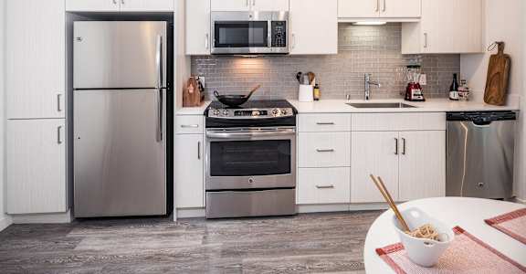 A modern kitchen with a refrigerator, oven, and microwave. at G12 Apartments, Los Angeles, CA, 90015