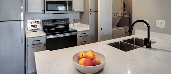 A kitchen with a bowl of fruit on the counter.