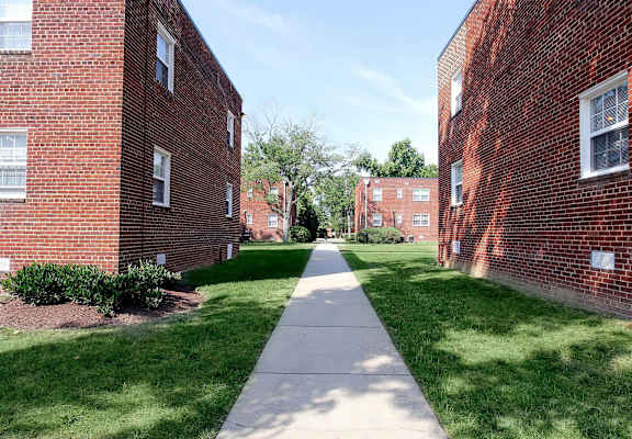 a walkway between two brick buildings on a sunny day at Parkland Village, Forestville, MD 20747