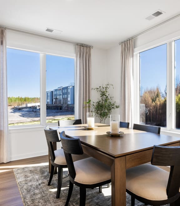 a dining room with large windows and a wooden table and chairs at Stonehill at West Orange, West Orange, New Jersey