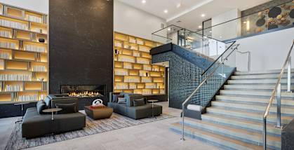 a lobby with couches and a staircase and a fireplace at Stonehill at West Orange, West Orange, New Jersey