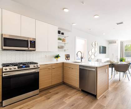A modern kitchen with wooden cabinets and a stainless steel oven.