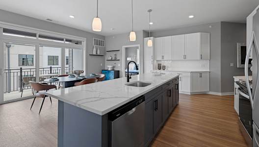 an open kitchen and dining room with a large marble counter top