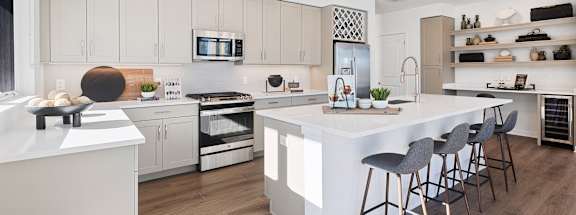 a large white kitchen with a large island and bar stools at Stonehill at West Orange, West Orange, New Jersey