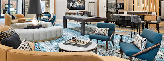 a large living room with couches and chairs and a pool table