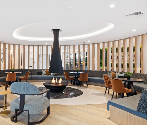 the lobby of a hotel with chairs and tables and a fireplace