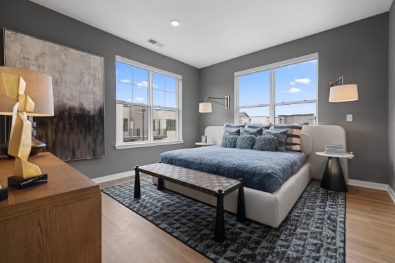 a bedroom with a bed and two windows