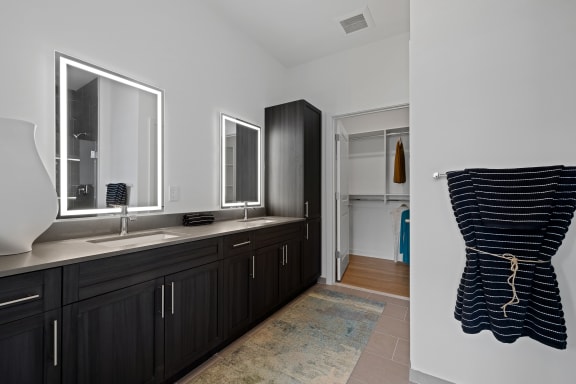 a black and white bathroom with a sink and mirrors