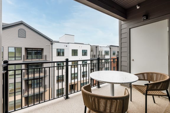 a patio with a table and chairs on a balcony