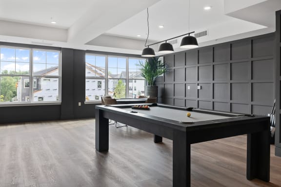 a games room with a pool table and a view of the city