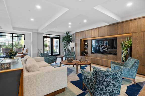 A living room with a large couch, a chair, and a television.