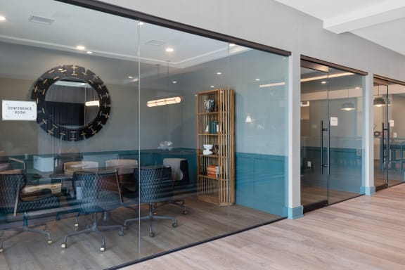 a conference room with glass walls and a mirror