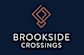 A logo with the text "Brookside Crossings" in front of a dark background.