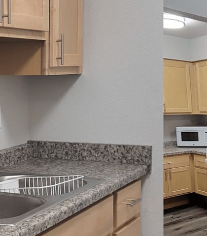 A kitchen with wooden cabinets and a granite countertop.