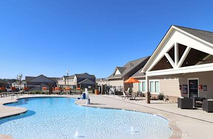 A pool surrounded by a building with a sign that says "Limited Time Special 1 Month Free on Select Apartment Homes when you move in by 3/31/2025!".