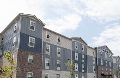 Apartment complex with a sign offering a 1 month free on select apartments if moved in by 4/30/2025.