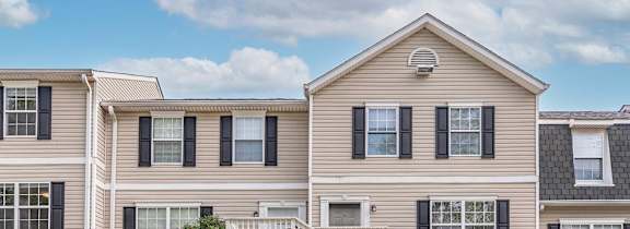 A two-story house with a staircase leading to the front door.