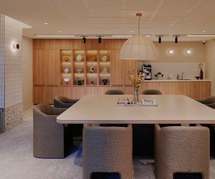 A conference room with a long table surrounded by chairs.