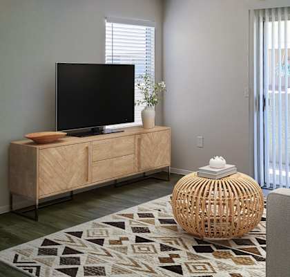 a living room with a tv on a stand in front of a sliding glass door  at Silver Creek Apartments, Nevada, 89122