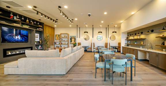 A modern kitchen and living room with a long white sofa.