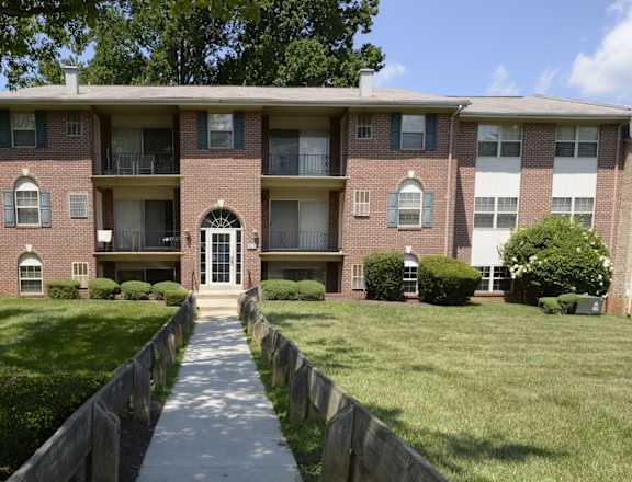 A brick apartment building with a white door and windows.