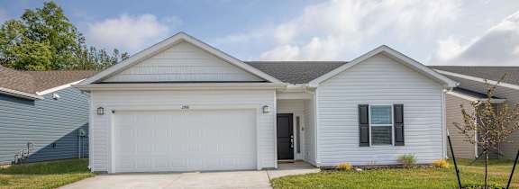 A white house with a garage door and a driveway.