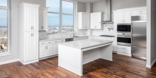 a large white kitchen with a large island in the center