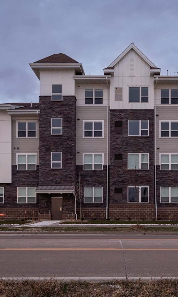 A large apartment building with multiple balconies and windows.