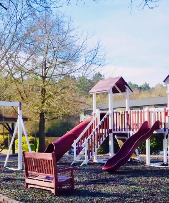 a childrens playground with slides and a swing set at Uphill Flats, Decatur, 30032