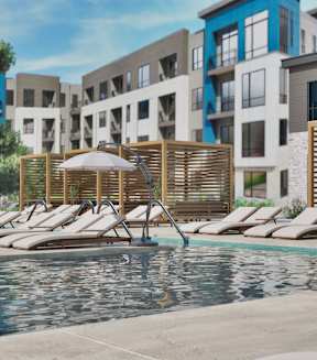 A pool area with sun loungers and a building in the background.