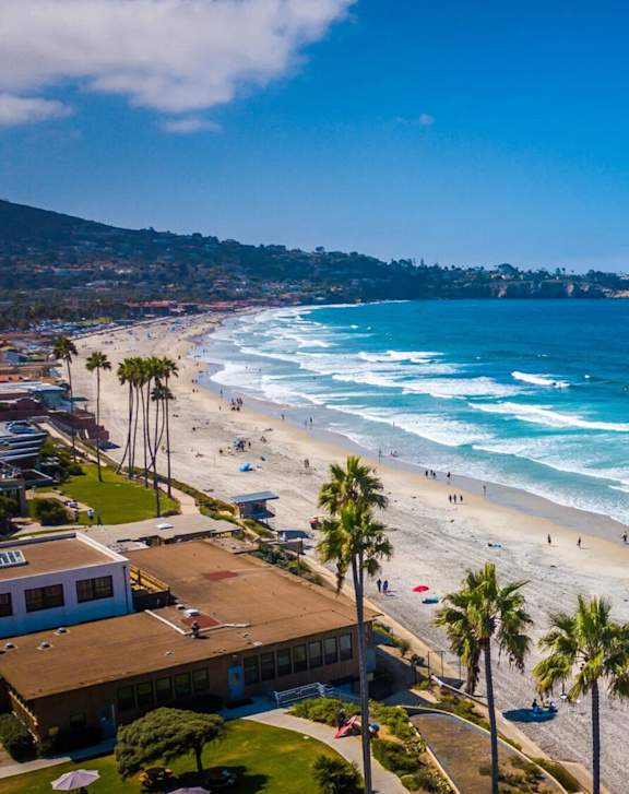 A beautiful beach with people enjoying the sun and the waves.
