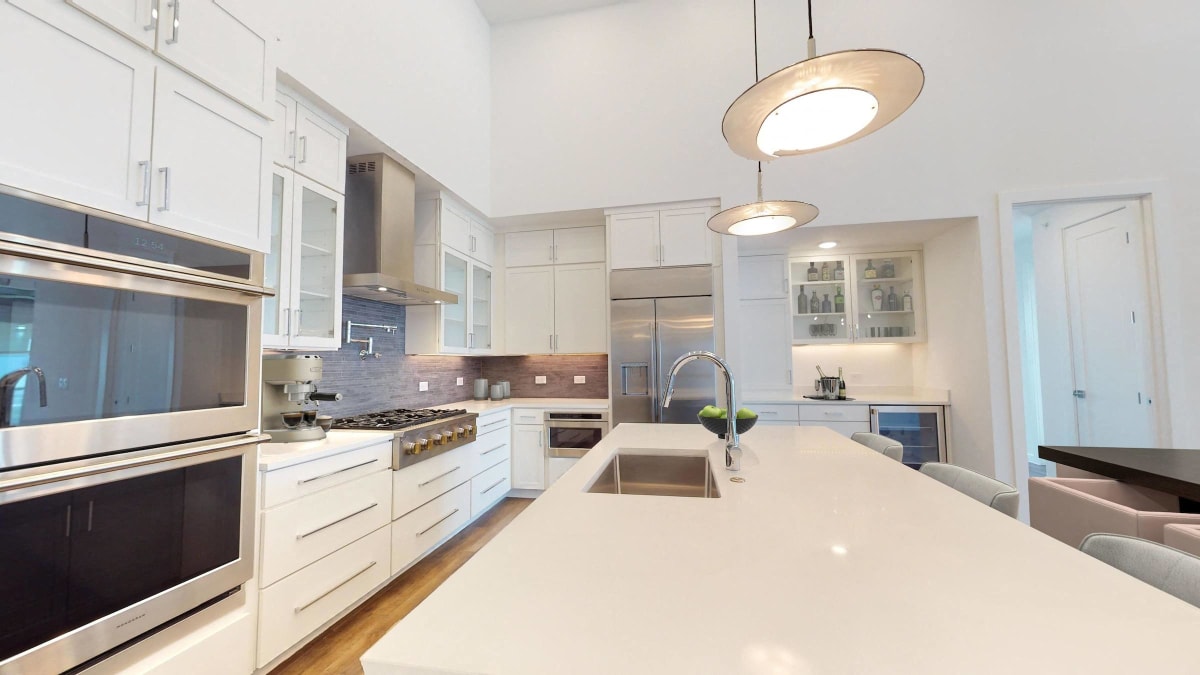 Stunning Modern Green Penthouse Apartment With White Quartz Countertops And Recycled Glass Backsplash image