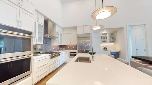 a large kitchen with a white counter top and a sink