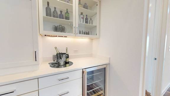 a small kitchen with white cabinets and white counter tops and a white counter top refrigerator