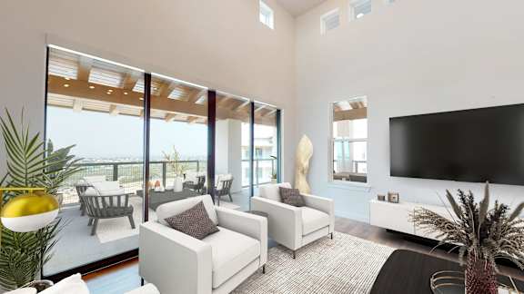 a living room with white furniture and a large television