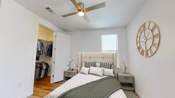 a bedroom with a bed and a large clock on the wall