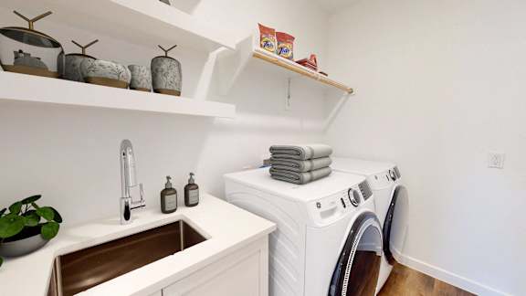 a small laundry room with a washing machine and sink