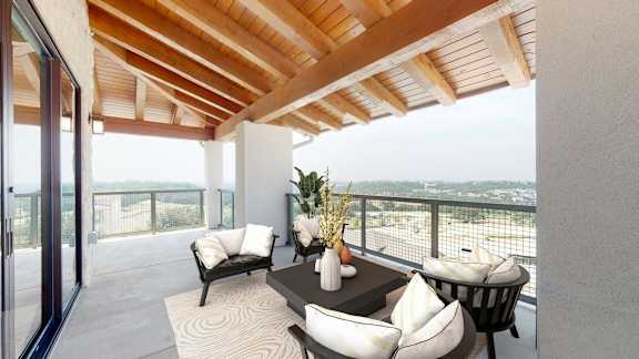 a living room with a table and chairs on a balcony